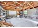Spacious outbuilding with concrete floor and walls, wooden rafters, peg boards, window, and storage at 829 Colleton Rd, Raleigh, NC 27610