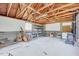 Interior outbuilding with exposed rafters, concrete walls and floor, shelves, and an old-fashioned stove at 829 Colleton Rd, Raleigh, NC 27610
