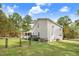 View of backyard featuring gray house siding, a black fence, a firepit, and green grass at 83 Wahoo Dr, Clayton, NC 27520