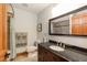 Well-lit bathroom featuring a dark vanity, a framed mirror reflecting the shower with tile surround, and neutral walls at 932 Gynnis Creek Dr, Moncure, NC 27559