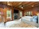 Cozy bedroom showcasing wood walls, a stone fireplace, and access to an outdoor balcony at 932 Gynnis Creek Dr, Moncure, NC 27559