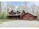 Spacious log home with a covered front porch, two-car garage, and lush green lawn at 932 Gynnis Creek Dr, Moncure, NC 27559