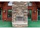 Exterior view of the stone fireplace, windows, and green door providing backyard access at 932 Gynnis Creek Dr, Moncure, NC 27559