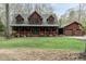 Charming log home with a covered front porch and dormer windows adjacent to matching two-car garage at 932 Gynnis Creek Dr, Moncure, NC 27559