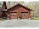 Exterior shot of a spacious two-car garage with carriage doors and a well maintained gravel driveway at 932 Gynnis Creek Dr, Moncure, NC 27559