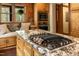 Modern kitchen features a large island with cooktop, granite counters, built in microwave and a window seat at 932 Gynnis Creek Dr, Moncure, NC 27559