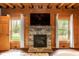 Comfortable living room with stone fireplace, TV and large windows overlooking the yard at 932 Gynnis Creek Dr, Moncure, NC 27559
