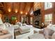 Relaxing living room features a stone fireplace, TV, hardwood floors and vaulted wood ceiling at 932 Gynnis Creek Dr, Moncure, NC 27559