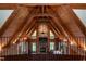 Balcony view overlooking a living room with wood ceilings, a stone fireplace, and natural light at 932 Gynnis Creek Dr, Moncure, NC 27559