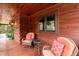 Outdoor patio featuring wooden siding, windows, comfortable seating and view of the backyard at 932 Gynnis Creek Dr, Moncure, NC 27559