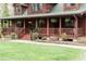 Cozy front porch featuring hanging ferns, wood railings, stone walkway, and a green front door at 932 Gynnis Creek Dr, Moncure, NC 27559