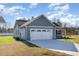 Side view of a home showcasing a two-car garage and well-maintained lawn at 104 Burnello Ct, Princeton, NC 27569