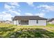 Rear exterior featuring gray siding, covered patio, and lush lawn at 104 Burnello Ct, Princeton, NC 27569