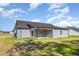 Rear exterior view of home with gray siding and covered patio at 104 Burnello Ct, Princeton, NC 27569