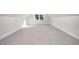 Finished attic space with neutral carpet, base trim, and view of the outdoors at 104 Roma Gora Ct, Princeton, NC 27569