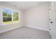 Neutral bedroom has carpet, white trim, and a bright window overlooking the side yard at 104 Roma Gora Ct, Princeton, NC 27569