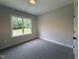 Neutral bedroom with a window view bringing in natural light and plush gray carpeting at 104 Roma Gora Ct, Princeton, NC 27569