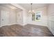 Bright dining room with modern chandelier, wainscoting, and rich wood-look flooring at 104 Roma Gora Ct, Princeton, NC 27569