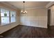 Bright dining room featuring an elegant chandelier, decorative wainscotting, and hardwood floors at 104 Roma Gora Ct, Princeton, NC 27569