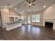 Open concept living area featuring hardwood floors, a stone fireplace, and views of the kitchen at 104 Roma Gora Ct, Princeton, NC 27569