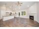 Open-concept living room showcasing hardwood floors, a fireplace, and a modern kitchen at 104 Roma Gora Ct, Princeton, NC 27569