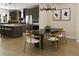 Dining area with modern lighting, a large table, and a view of the modern kitchen at 1045 Zelkova Ln, Chapel Hill, NC 27517
