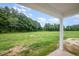 View of a large backyard with mature trees from a covered patio area at 105 Tuskeegee Dr, Smithfield, NC 27577
