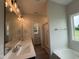 Bright bathroom with double vanity, quartz countertop, and large mirror with decorative lighting at 105 Tuskeegee Dr, Smithfield, NC 27577