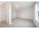 A bedroom with a large window, neutral carpeting, and an adjoining walk-in closet at 105 Tuskeegee Dr, Smithfield, NC 27577