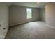 Carpeted bedroom with a neutral paint and a window to view the neighborhood at 105 Tuskeegee Dr, Smithfield, NC 27577