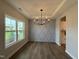 Bright dining room boasts a large window and a modern chandelier, creating an inviting atmosphere for meals at 105 Tuskeegee Dr, Smithfield, NC 27577