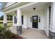Inviting front porch with stone-based columns and a stylish black door, perfect for welcoming guests at 105 Tuskeegee Dr, Smithfield, NC 27577