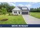 Charming home with white siding, stone accents, black garage doors, and a well-manicured lawn at 105 Tuskeegee Dr, Smithfield, NC 27577