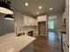 Modern kitchen with white cabinetry, stainless steel appliances, eat-in island, and modern pendant lights at 105 Tuskeegee Dr, Smithfield, NC 27577