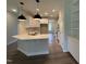 Modern kitchen with white cabinetry, eat-in island, stainless steel appliances, and sleek pendant lighting at 105 Tuskeegee Dr, Smithfield, NC 27577