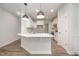 Modern kitchen with an island, white cabinets, stainless steel appliances, and sleek pendant lighting at 105 Tuskeegee Dr, Smithfield, NC 27577