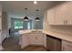 Open kitchen layout with a modern island, stainless steel dishwasher and sink, with adjacent living room view at 105 Tuskeegee Dr, Smithfield, NC 27577