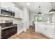 A modern kitchen boasts white cabinets, stainless steel appliances, and stylish pendant lighting at 105 Tuskeegee Dr, Smithfield, NC 27577
