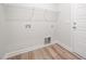 A simple laundry room with white walls, flooring, and washer/dryer hookups at 105 Tuskeegee Dr, Smithfield, NC 27577