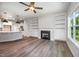 Cozy living room with a fireplace, built-in shelves, ceiling fan, and adjacent modern kitchen at 105 Tuskeegee Dr, Smithfield, NC 27577