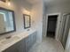 Bathroom with dual sinks, quartz countertops, and a glass-enclosed shower with tile flooring at 106 Roma Gora Ct, Princeton, NC 27569