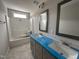 Modern bathroom featuring a double vanity with gray cabinets and shower with white tiling and neutral gray walls at 106 Roma Gora Ct, Princeton, NC 27569