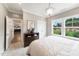 Bright bedroom featuring a dresser, plush carpet, and a view of the green yard through the double window at 108 E Fountainhead Ln, Garner, NC 27529