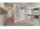 Upstairs hallway with carpet, striped accent wall, iron railing, and open doorways at 108 E Fountainhead Ln, Garner, NC 27529