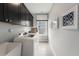 Well-lit laundry room featuring washer, dryer, sink, overhead cabinets, and bright natural light from a large window at 108 E Fountainhead Ln, Garner, NC 27529