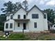 Charming two-story home with a white brick and siding exterior, complemented by black-framed windows at 1116 Kimberly Dr, Raleigh, NC 27609