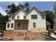 New two-story home features white brick, black framed windows and a covered front porch at 1116 Kimberly Dr, Raleigh, NC 27609