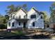 Two story home under construction, featuring black windows, Tyvek wrap, and a covered front porch at 1116 Kimberly Dr, Raleigh, NC 27609