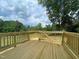 Newly constructed wooden deck with railing, offering a great outdoor living space and scenic views of surrounding greenery at 112 Remington Woods Dr, Wake Forest, NC 27587