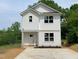 New two-story home with white siding, a concrete driveway, and landscaping with a harmonious blend of design and natural elements at 112 Remington Woods Dr, Wake Forest, NC 27587